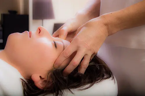 Élève pratiquant la réflexologie faciale lors d’une formation certifiante au CFATBE