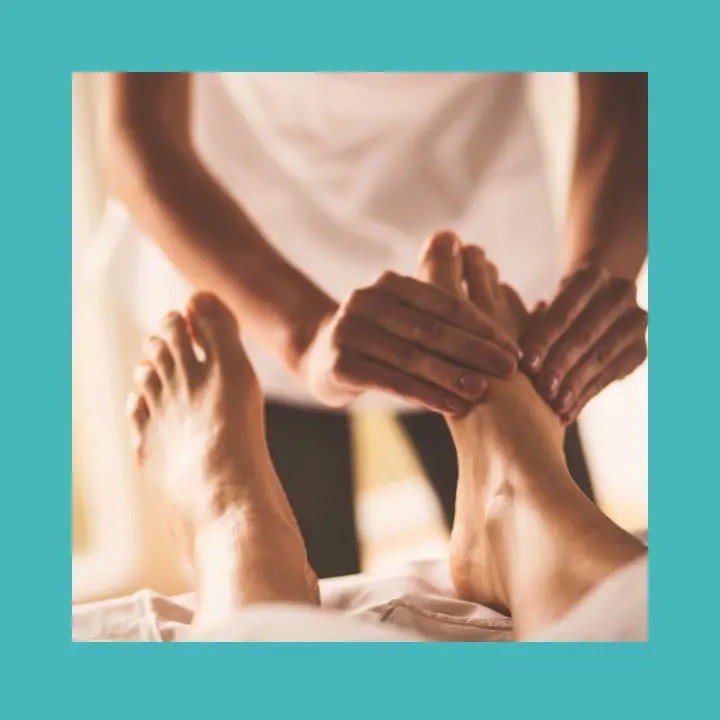 Praticien effectuant un massage métamorphique sur les pieds d'un client allongé