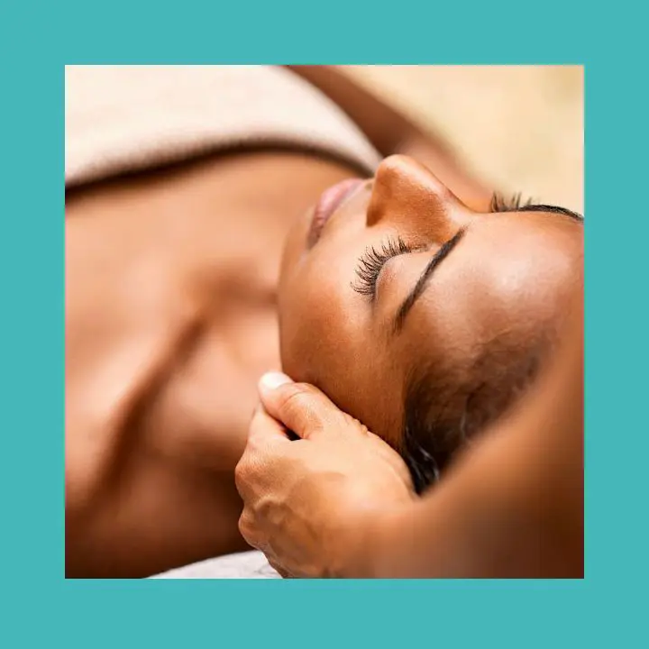 Massage métamorphique appliqué doucement sur la tête d'une femme détendue pendant une séance en présentiel